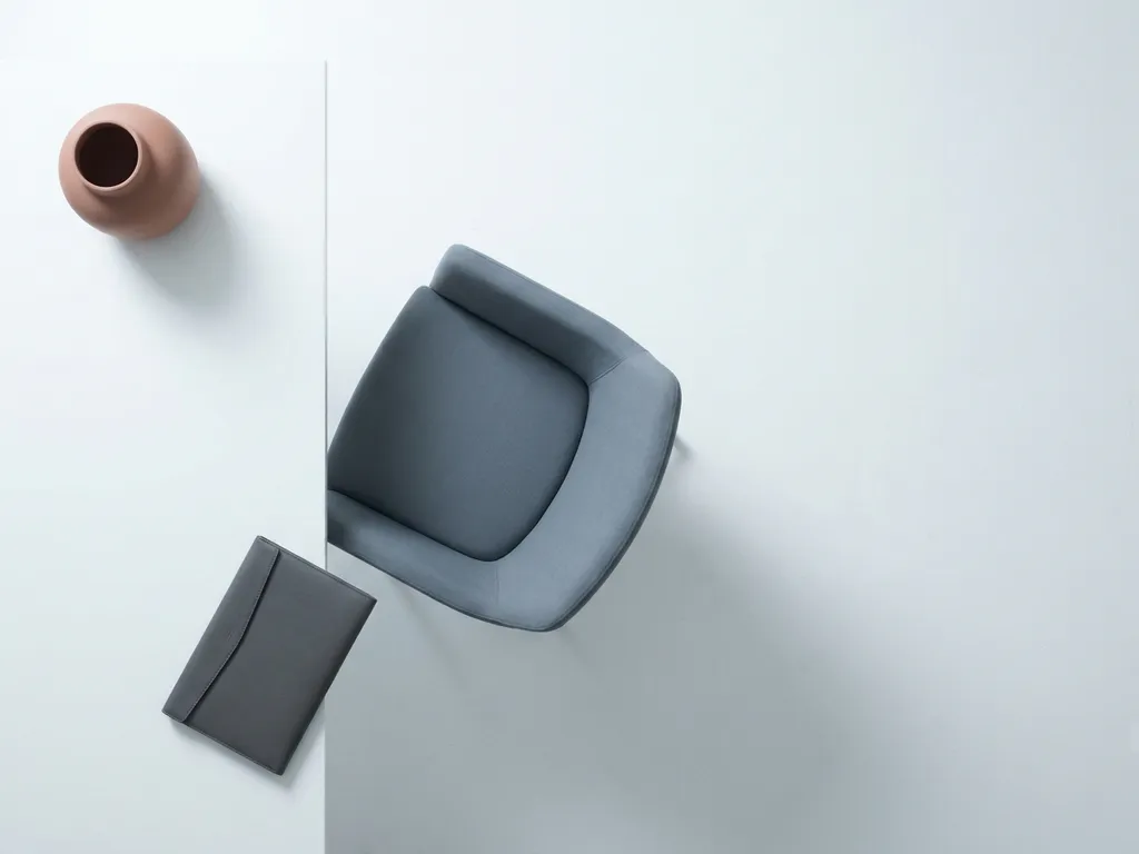 Lege interviewstoel aan een strak tafel met een gesloten portfolio, gefotografeerd van bovenaf in minimalistische stijl.